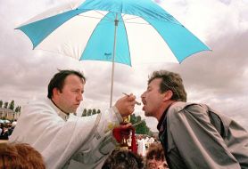Catholic priest administers communion to believers 