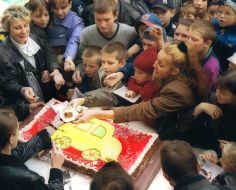 Kids are seen waiting to taste a piece a huge 42-kilogram cake