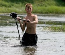 Teenager extracts coal from the Calmius river floor