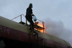 Сотрудники МЧС закручивают крышку цистерны с желтым фосфором
