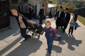 Kids wheelbarrow the baggage of Hasids