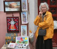 Пожилая женщина продает картины