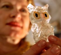 Женщина держит в руках фигурку совы