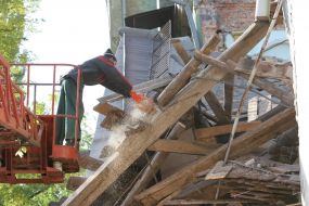 Рабочий возле обрушившейся школьной пристройки