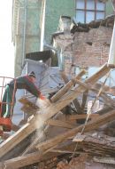 Рабочий возле обрушившейся школьной пристройки