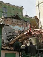 Рабочий возле обрушившейся школьной пристройки