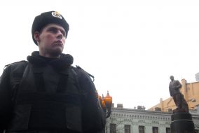 Militiamen near a monument to Lenin