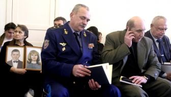 Ekaterina Senik with portraits of her dead relatives