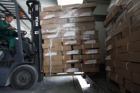 Worker transports chicken hams in storage