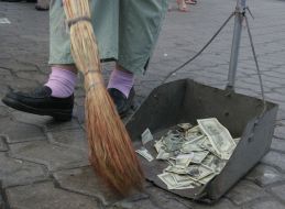 Работница комунальной службы убирает ”деньги”