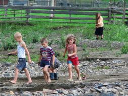 Children go on the washed out road