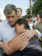 Ющенко утешает жительницу одного из потерпевших сел