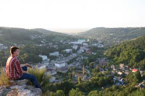 A tourist sits on ruins of walls of ancient fortress