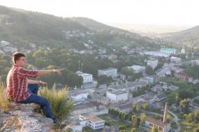 A tourist sits on ruins of walls of ancient fortress
