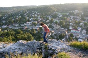 A tourist goes down from ruins of walls of ancient fortress