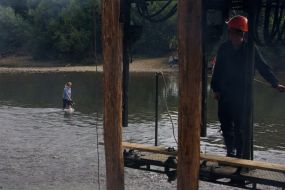 Місцева мешканка переходять річку