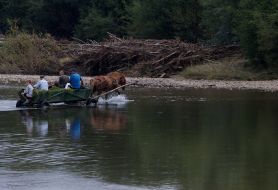 Місцеві мешканці переїжджають на возі річку
