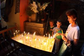 A believer puts a candle