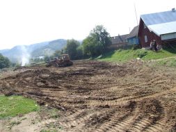 Місцеві мешканці спостерігають за роботою тракторів