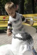 Мальчик раскрашивает гипсовую фигуру
