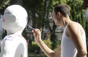 Мужчина раскрашивает гипсовую фигуру