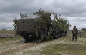 Soldier looks at loading of military car
