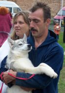 Хозяин держит на руках собаку породы Лайка