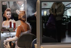 Парикмахер делает прическу модели