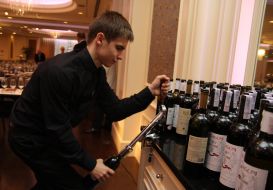 Barman opens bottle with wine