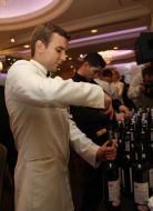 Barman opens bottle with wine