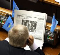 A deputy reads a newspaper