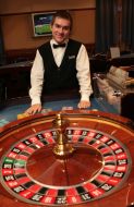 A croupier stands near roulette