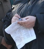 A woman checks up the picket participants lists for money payment