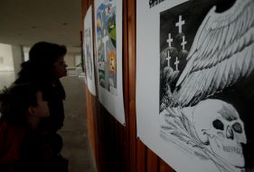 Visitors examine pictures on an exhibition