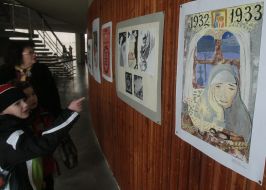 Visitors examine pictures on an exhibition