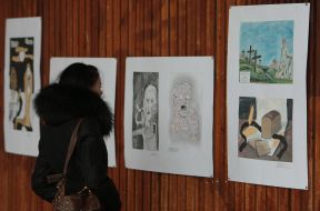 A visitor examines one of exhibition works