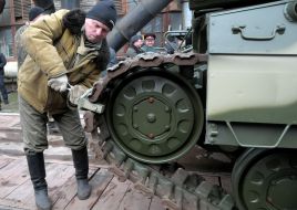 Рабочий ставит стопор на гусеницу нового танка