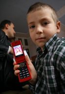 Мальчик показывает иконку на мобильном телефоне