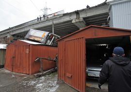Грузовик, лежащий на гаражах