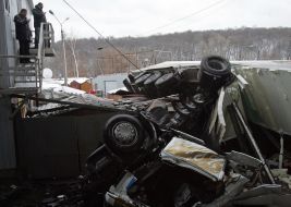 Грузовик, лежащий на гаражах