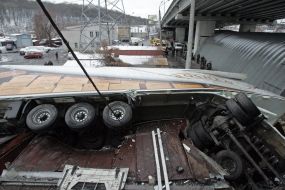 Грузовик, лежащий на гаражах