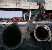 Сотрудник МЧС тянет пожарный шланг