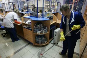 Уборщица моет пол в аптеке