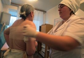 Медсестра накладає бинт постраждалій жінці