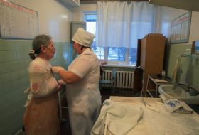 Медсестра накладає бинт постраждалій жінці