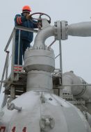 A worker twirls a valve