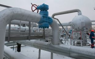 A worker twirls a valve