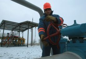 A worker twirls a valve