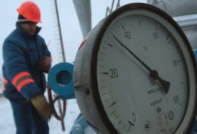A worker twirls a valve