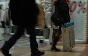 Люди проходять біля вітрин магазинів